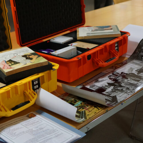 Two plastic suitcases pictured open ad full of images, tools and guidance on science in art.